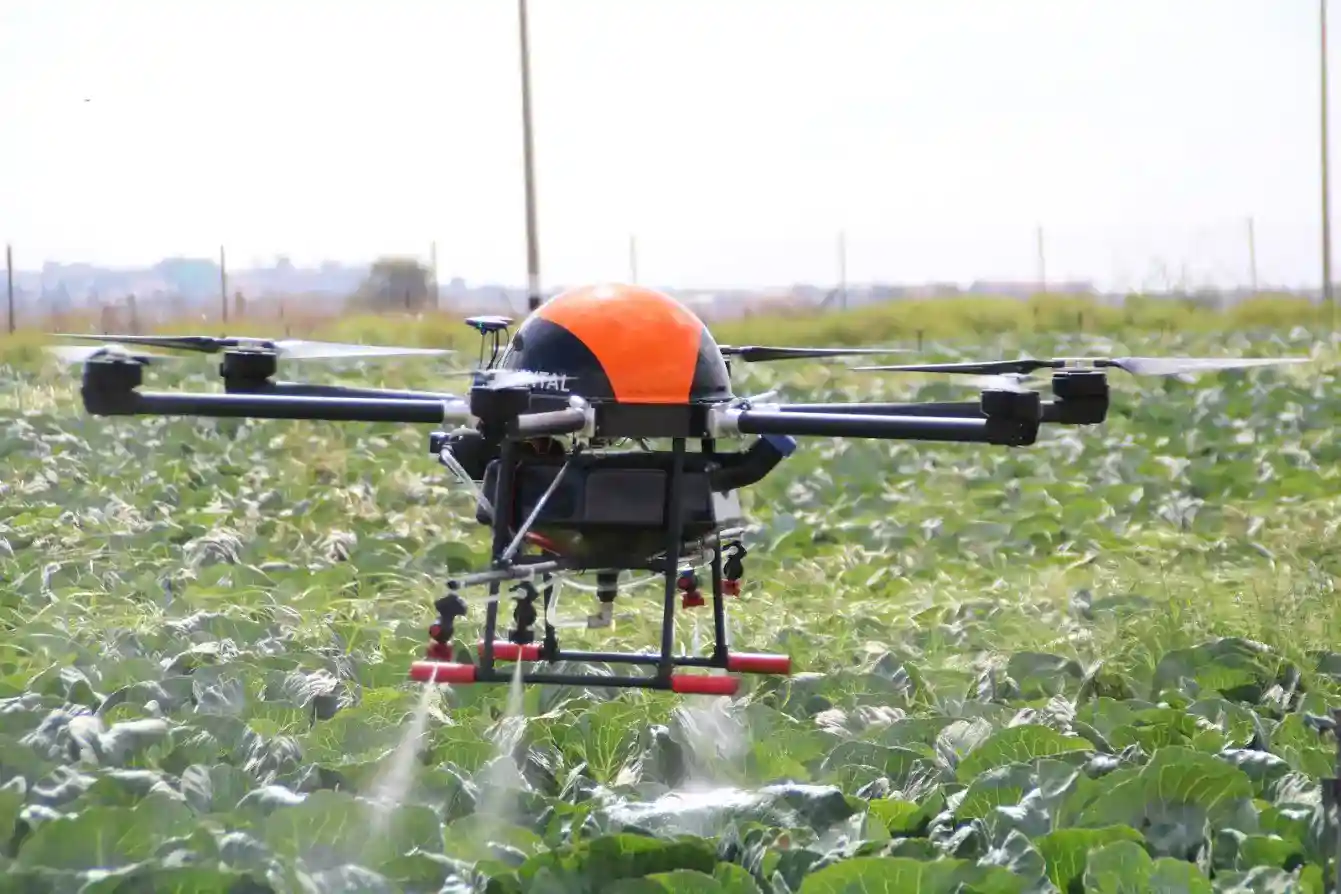 Drone sobrevolando un campo y tractor de fondo